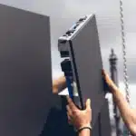 Technician installing an LED screen panel on an outdoor display structure