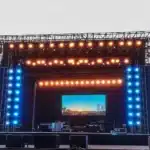 Outdoor event stage with large LED screens and lighting rig