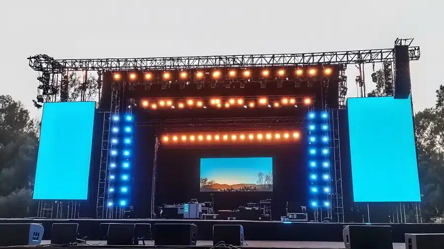 Outdoor event stage with large LED screens and lighting rig