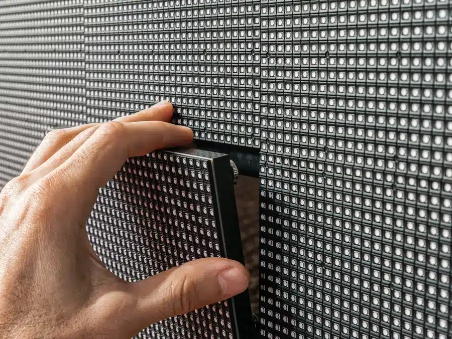 Technician removing an LED video wall panel during installation or maintenance of a modular LED display